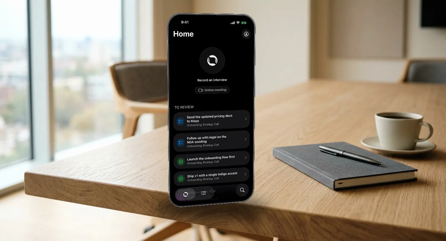 A meeting room: the Eily app on a phone in a stand, recording, five live cards appearing as the conversation runs.